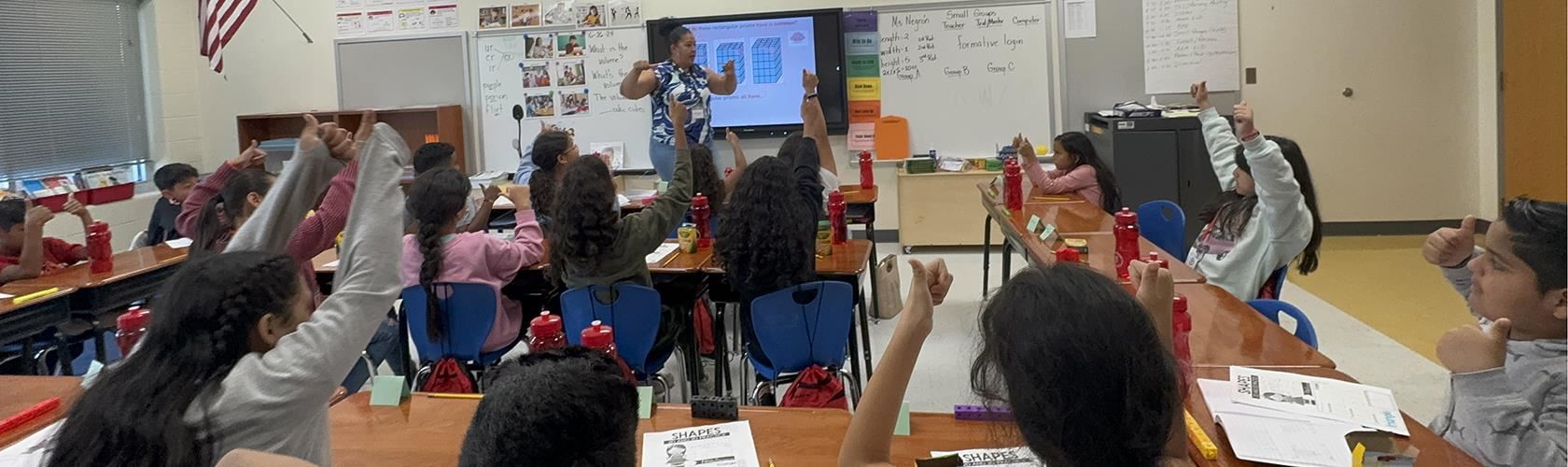 ML students responding to a question with thumbs up in summer language academy class at South Pine Elementary 